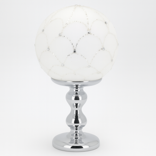 Lume decorativo Bagutta con sfera bianca decorata con strass e base argentata.